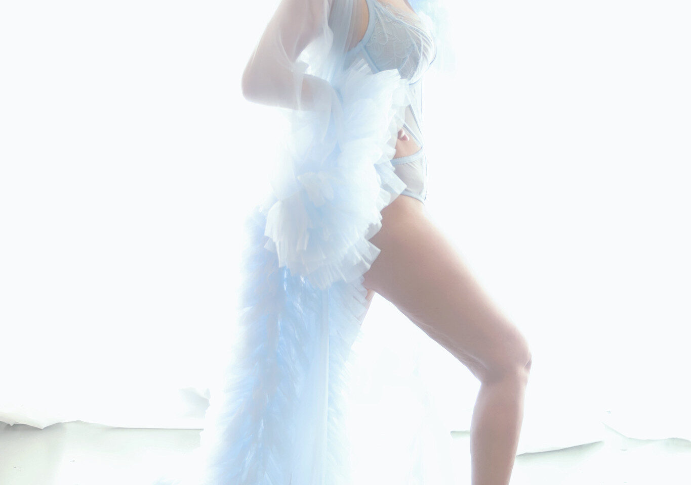 Ethereal boudoir portrait in a pale blue feathered gown