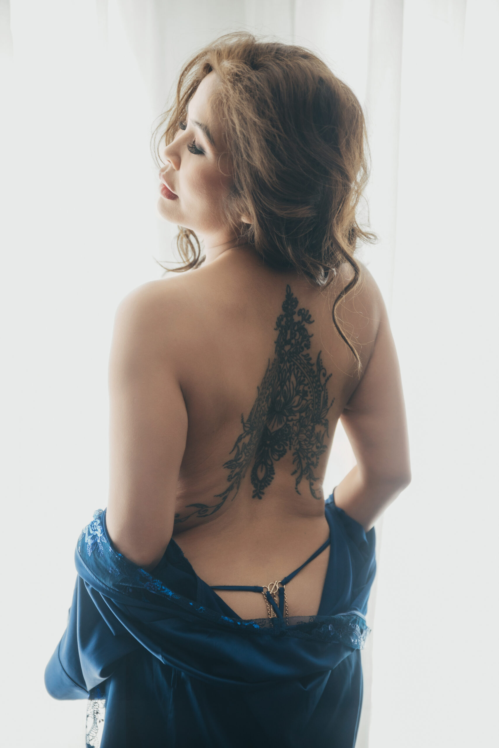 Back view boudoir portrait in blue velvet with lace detail