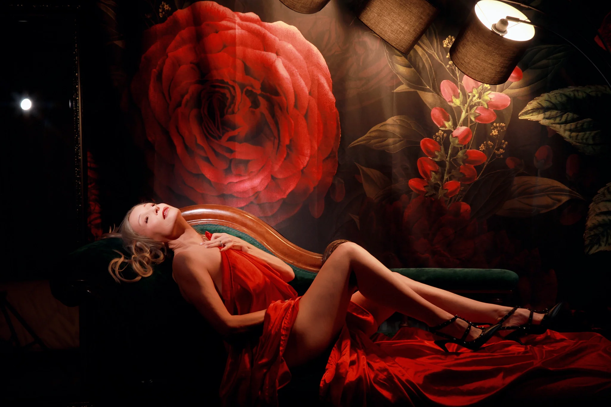 Dramatic red gown boudoir portrait against a floral backdrop