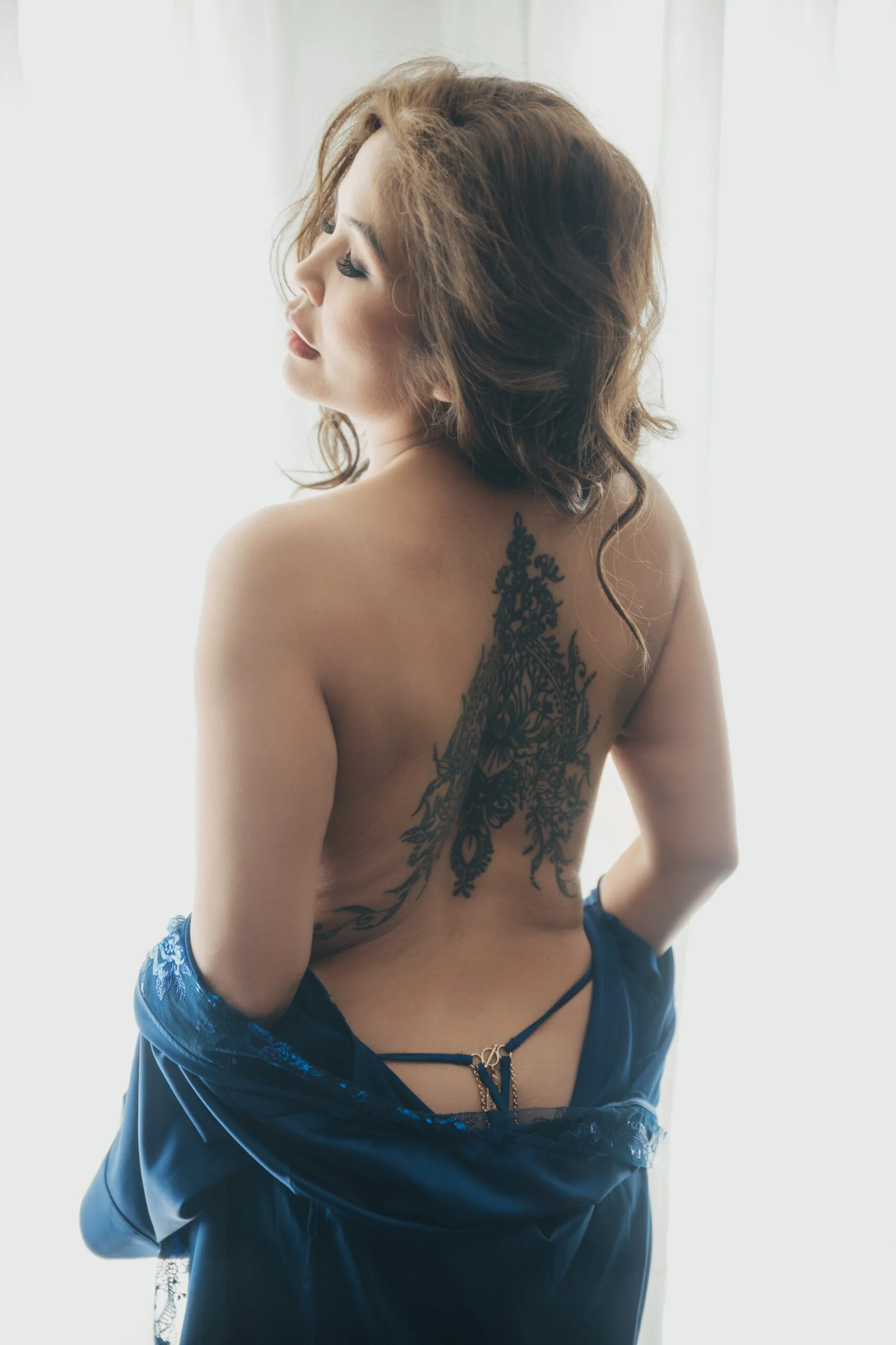 Back view boudoir portrait in blue velvet with lace detail
