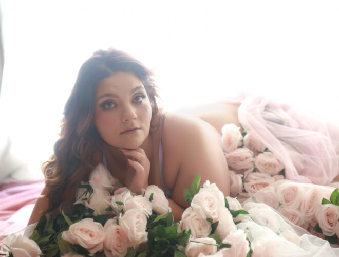 Curvy woman surrounded by pink roses, Plus Size Boudoir in Melbourne at My Story Boudoir Melbourne