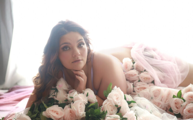 Curvy woman surrounded by pink roses, Plus Size Boudoir in Melbourne at My Story Boudoir Melbourne