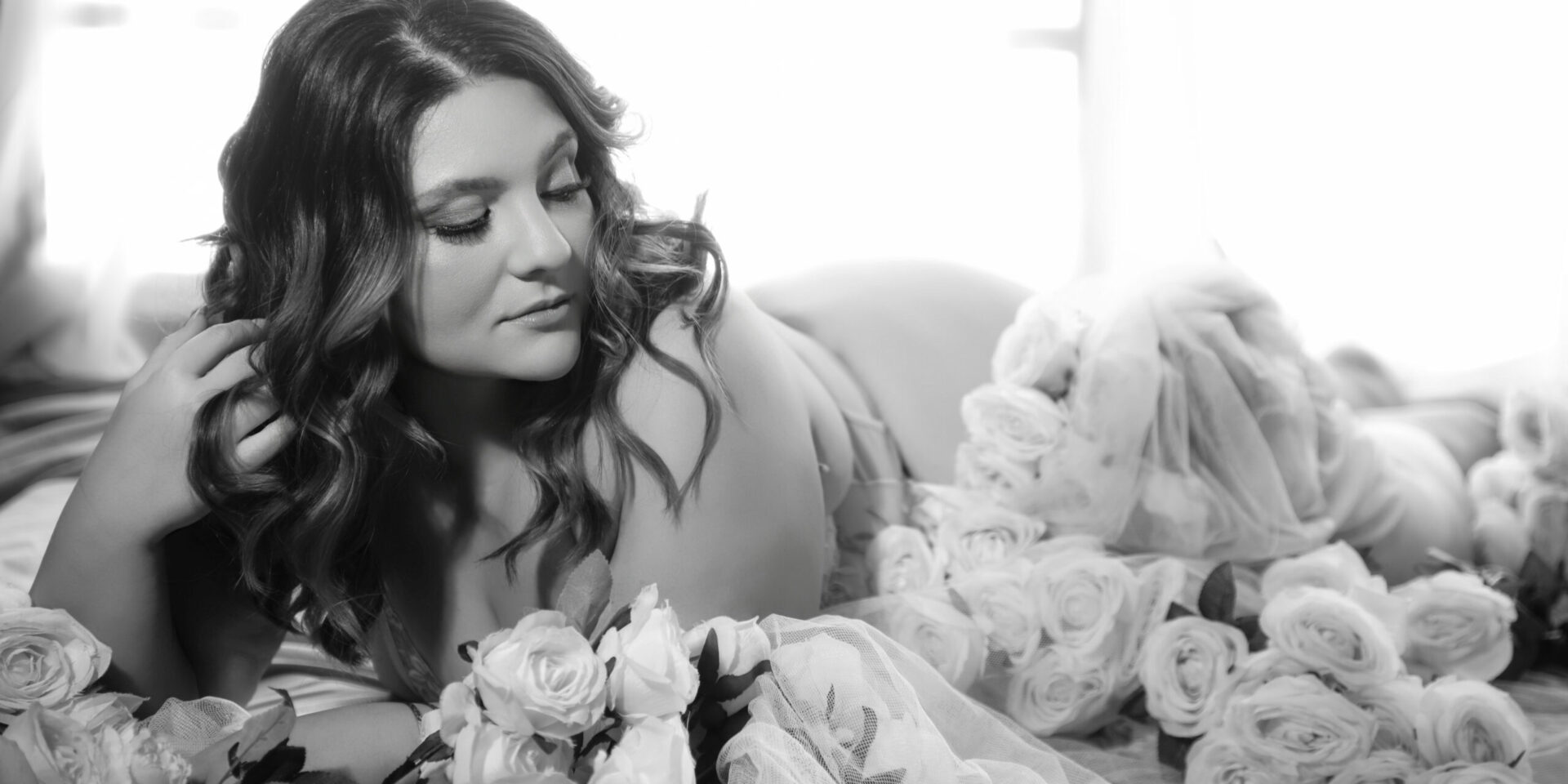 Curvy woman surrounded by pink roses, Bridal Boudoir in Melbourne at My Story Boudoir Melbourne